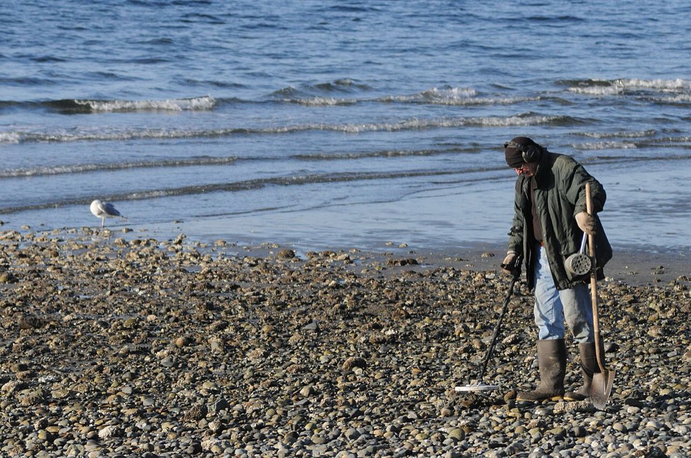A detectorist searching a beach