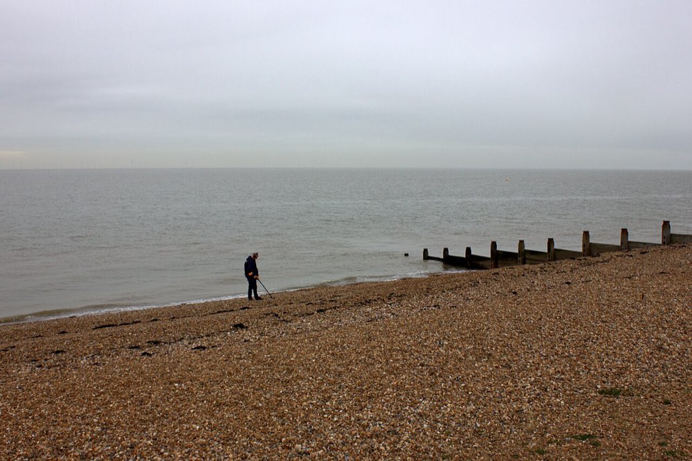 A beachcomber with a metal detector at Tankerton, Kent
