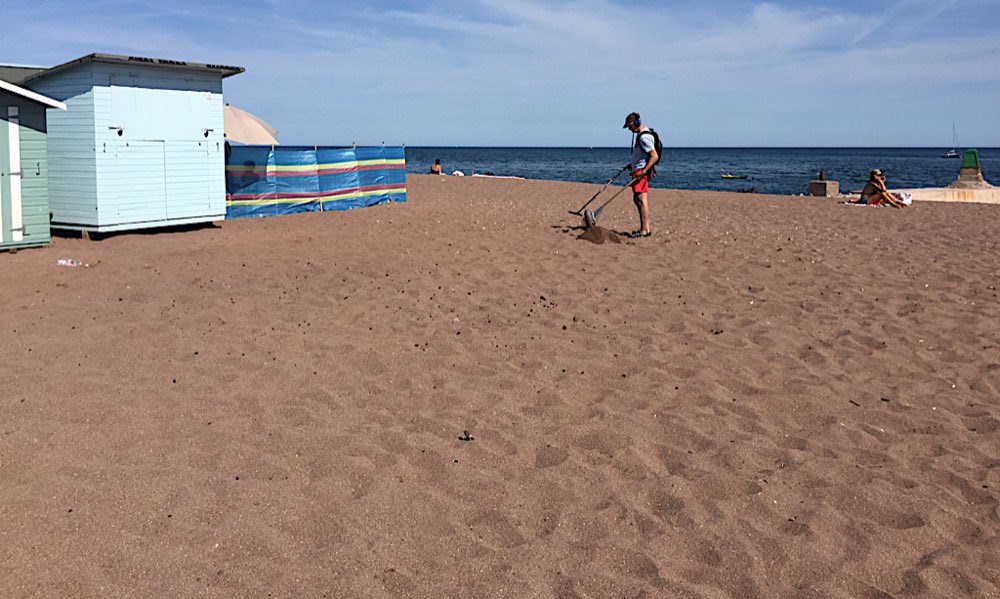 A detectorist on the beach at The Point, Teignmouth