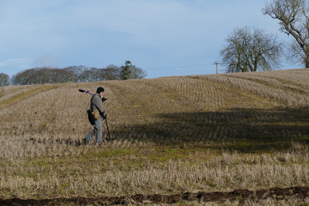 A detectorist searching with a metal detector